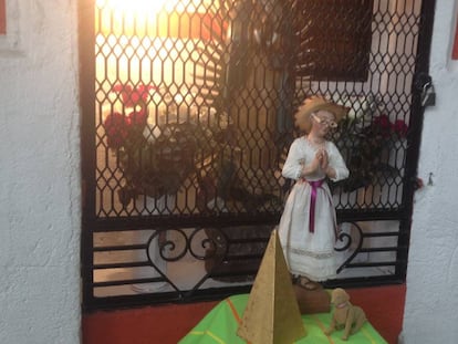 Santa Mari La Juaricua frente a un altar de la Virgen de Guadalupe.