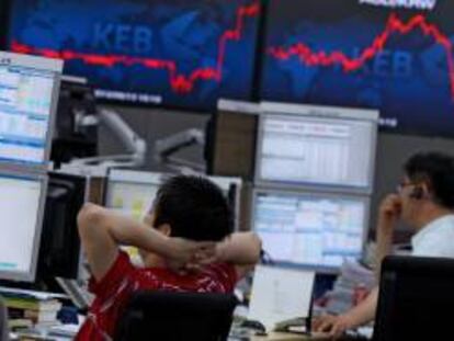 Corredores de bolsa surcoreanos vigilan las pantallas en la sede del Exchange Bank de Seúl (Corea del Sur). EFE/Archivo