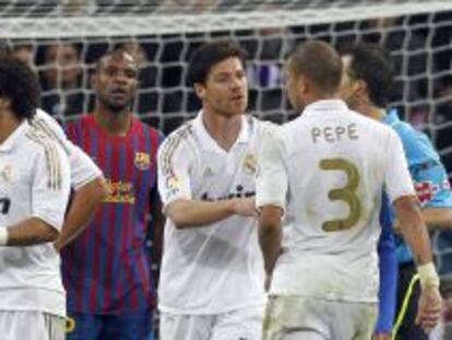Jugadores del Barça y el Madrid discuten en un lance de un partido.
