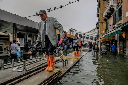 Um senhor caminha pelas passarelas improvisadas em Veneza depois da inundação causada pela maré alta, fenômeno que se conhece como 'acqua alta', que, nesta ocasião, subiu até os 156 centímetros (maior subida desde 2008).