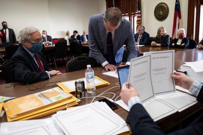 Shawn Still, now a Georgia Republican state senator, leans over to sign electoral certificates voting for Donald Trump and Vice President Mike Pence at the Georgia Capitol, Dec. 14, 2020, in Atlanta.