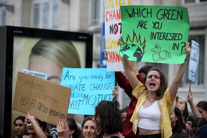 Una joven muestra una pancarta que lee "¿Qué verde prefieres?" haciendo referencia al planeta Tierra o al dinero, en la manifestación convocada en Madrid.