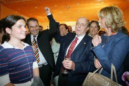 Manuel Fraga alza el brazo de Xosé Crespo, jefe de la campaña electoral del PP, en la fiesta que siguió al escrutinio de los resultados.