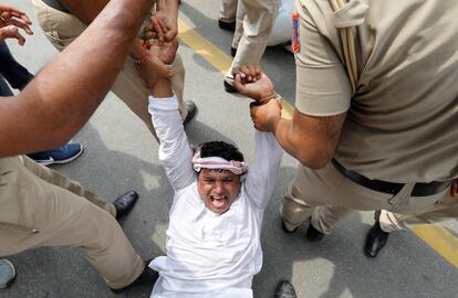 Agentes de policía detienen a un joven activista del principal partido opositor de la India durante una protesta en Nueva Delhi para exigir que el gobierno revele los detalles del trato con los aviones de combate Rafale.