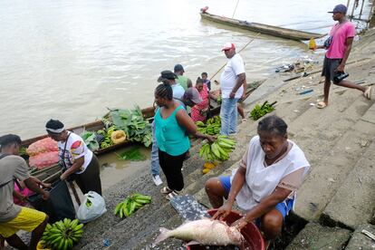 Una mujer venden pescado a los comerciantes locales a orillas del río Atrato en Quibdo , Colombia. En enero de 2023.
