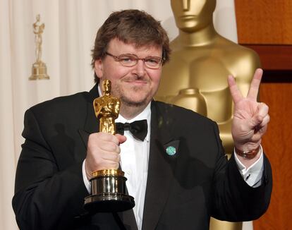 Michael Moore sostiene su Oscar haciendo el símbolo de la victoria.