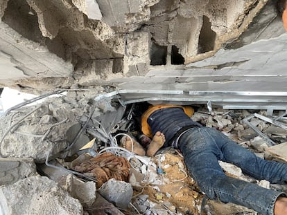 Un hombre intenta sacar el cuerpo de un familiar de entre los escombros tras el bombardeo del campo de Maghazi. 