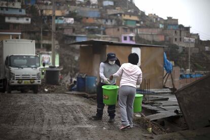 Los vecinos salen al llamado de la música del camión que recoge los cubos en los que se despositan las heces, antes trasladadas en bolsas.