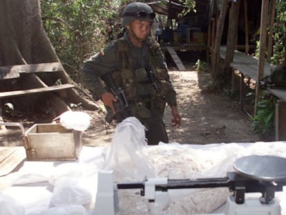 Un soldado mira bolsas de coca&iacute;na en un laboratorio clandestino en Colombia.
