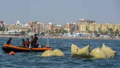 Buzos de la Unidad Militar de Emergencias posicionan los bloques de hormigón frente a la playa de la Malvarrosa de Valencia.