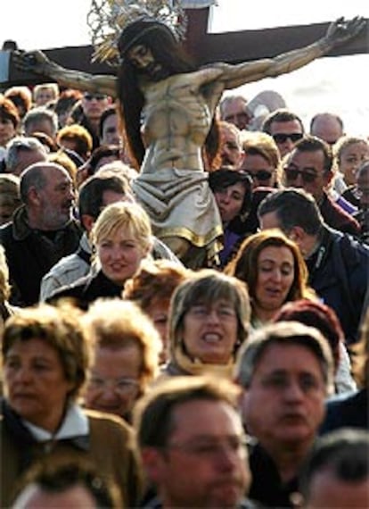 Una multitud regresa con la imagen de la hermandad del Santísimo Cristo del Salvador durante la procesión realizada a primera hora de la mañana en Valencia para rezar en la orilla por los difuntos del mar y las víctimas del 11-M.