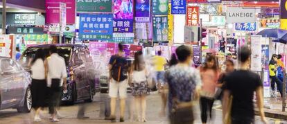 Varias personas pasean por la zona comercial de Mlongkok, en Hong Kong.