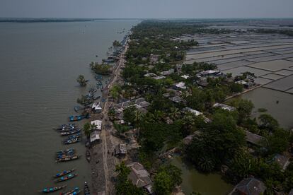 Vista aérea de la isla de Gabura, en el distrito de Satkhira. A la izquierda, el río Kholpetua, lleno de barcas de pesca. A la derecha, las charcas de agua salada donde crían gambas y
cangrejos. Ambos están separados por el estrecho camino de tierra que solamente se puede recorrer en moto o a pie.