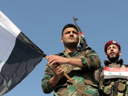 Dos soldados sirios ondean la bandera del país en una imagen de archivo.