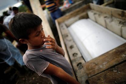 Un niño junto al ataúd de Jakelin Caal, la niña de siete años que murió detenida el 8 de diciembre, durante el entierro en San Antonio Secortez, Guatemala.
