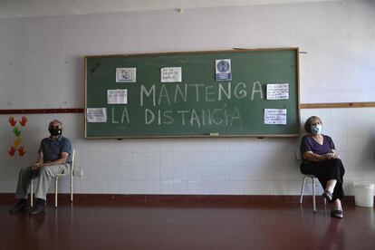Ancianos esperan para salir después de recibir la primera dosis de Sputnik V, en un centro de vacunación temporal en una escuela pública en Ezeiza, Argentina.