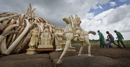 Los trabajadores pasan junto a las esculturas de marfil, en el Parque Nacional de Nairobi, Kenia.
