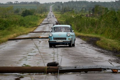 Una familia en su pequeño auto conduce por un camino destruido tras el paso del huracán Rafael en San Antonio de los Baños, Cuba, el 7 de noviembre de 2024. 