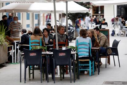 Varias personas disfrutan en una terraza en Valencia.