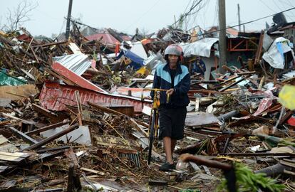Un hombre camina entre los escombros, de las casas destruidas por el tifon Yolanda, en la isla oriental de Leyte el 10 de noviembre de 2013.