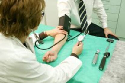 Un m&eacute;dico tomando la tensi&oacute;n a un paciente en un centro de trabajo.