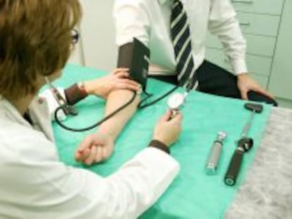 Un m&eacute;dico tomando la tensi&oacute;n a un paciente en un centro de trabajo.