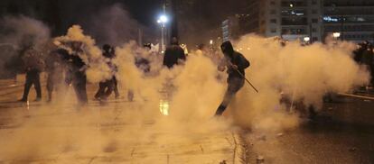 Un manifestante patea una lata de gas durante los enfrentamientos con los agentes.