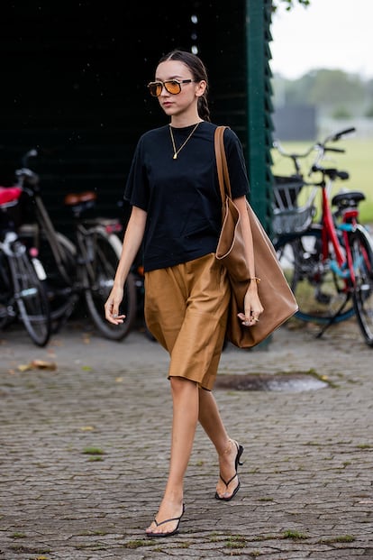 El que sería el conjunto playero perfecto (camiseta, bermudas, bolso XL y chanclas) puede convertirse también en el uniforme de oficina más cómodo y estiloso. Solo hay que seguir el esquema cambiando las prendas veraniegas por otras de tonos más oscuros y materiales sólidos como la piel.