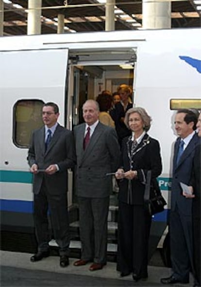 Los Reyes, acompañados de Lucas y de Ruiz-Gallardón, posan ante la puerta del tren en la estación de Atocha.