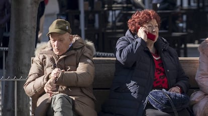 Un hombre y una mujer, ambos de avanzada edad, sentados en el centro de Sevilla.