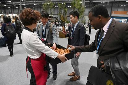 Varios asistentes comen churros a su llegada a la vigésimo quinta conferencia del clima de la ONU (COP25).