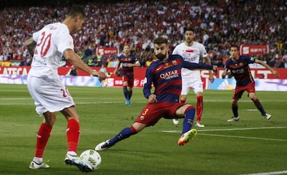 Gerard Piqué se enfrenta al jugador del Sevilla, Vitolo.