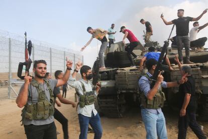 A group of Palestinians ride a military vehicle through the streets of Gaza on Saturday.