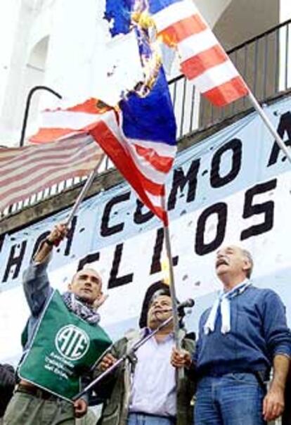 Trabajadores estatales argentinos quemaron ayer banderas americanas durante una manifestación en Buenos Aires.