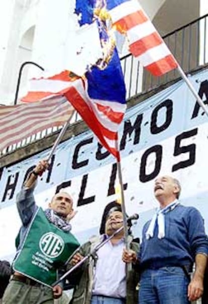 Trabajadores estatales argentinos quemaron ayer banderas americanas durante una manifestación en Buenos Aires.