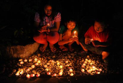 Unos niños colocan velas para celebrar el nuevo año en Surabaya, Indonesia.