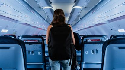 Una mujer saliendo de un avión con una mochila puesta.