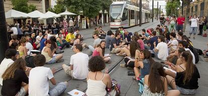 Un momento de la sentada en la que medio centenar de estudiantes universitarios interrumpieron el tranv&iacute;a de Sevilla.