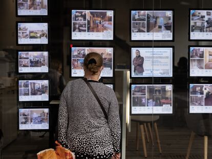 Una mujer mira anuncios de pisos en una inmobiliaria de Barcelona, en una imagen de archivo.