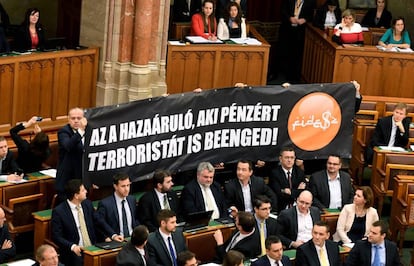Los parlamentarios de Jobbik muestran una pancarta acusando al Gobierno de abrir la puerta a terroristas por dinero.
