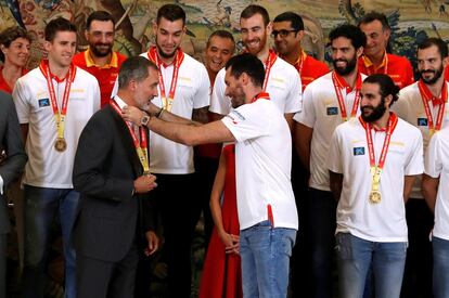 El rey Felipe recibe una medalla por parte de los jugadores de la selección española de baloncesto, en el Palacio de la Zarzuela. 