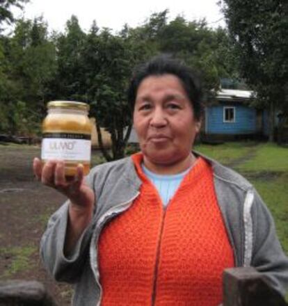 Rosa, campesina mapuche, muestra un tarro de miel de ulmo que produce y vende gracias a un programa de capital semilla para el emprendimiento de mujeres.