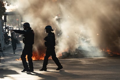 Agentes de policía pasan junto a una barricada en llamas frente al instituto Helene Boucher en Paris.