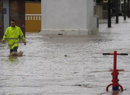 Un vecino de Puente Romano, en Los Barrios, ayer, tratando de sortear las balsas de agua provocadas por la borrasca en el Campo de Gibraltar.