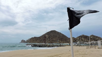 Una bandera negra, colocada para alertar a los turistas de olas altas y corrientes que no son seguras para nadar, se muestra en una playa de Baja California en México.