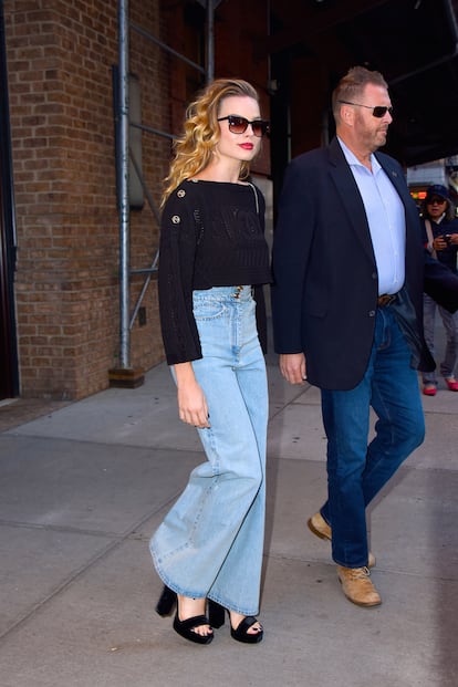 Margot Robbie con un pantalones vaqueros y jersey negro de Chanel.