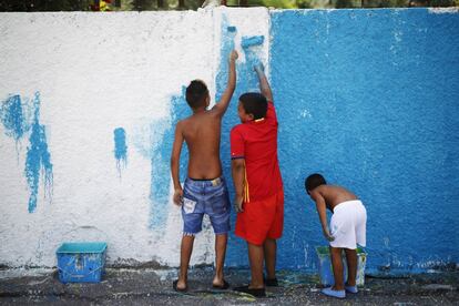 Los niños colaboran pintando las fachadas de la Cañada Real, junto con el colectivo de artistas urbanos Boa Mistura.