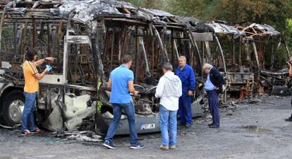 Agentes de la policia cientifíca y personal de la compañia toman datos de los cinco autobuses calcinados en la localidad de Loiu.