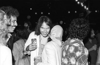 Neil Young, con una lata de cerveza en la mano, hablando con la cantante Nicolette Larson en la presentación de la película y disco 'Rust never sleeps' (donde se incluye 'Hey hey, my my (into the black)'. La fiesta fue en agosto de 1979 en Los Ángeles.