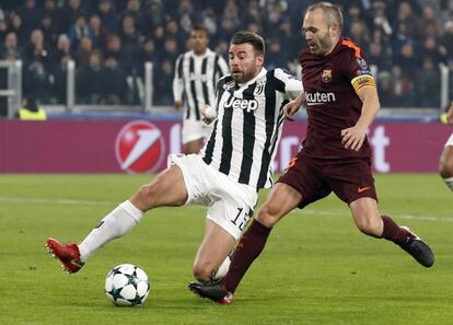 Disputa del balón entre el jugador del Juventus Andrea Barzagli y el barcelonista Andrés Iniesta.